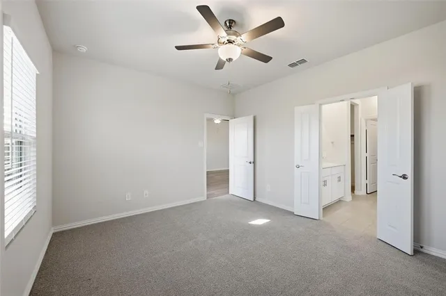 an empty room with fan and windows
