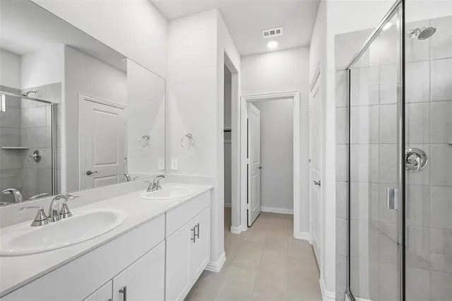 a spacious bathroom with a double vanity sink mirror and shower
