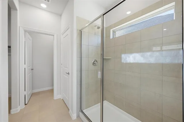 a bathroom with a shower and a glass door