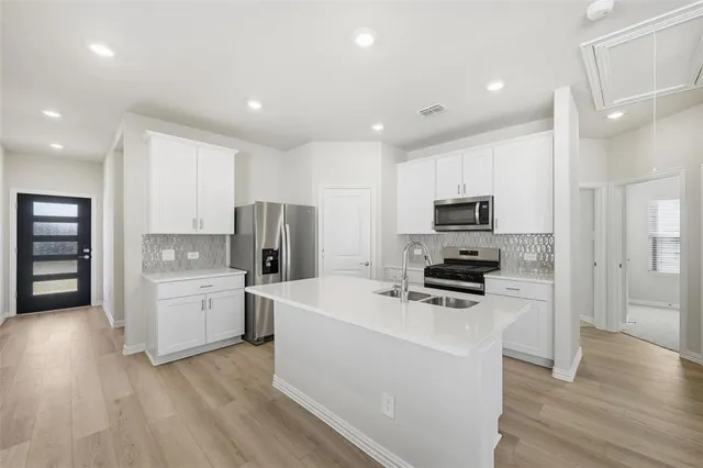a kitchen with a refrigerator a stove top oven and sink