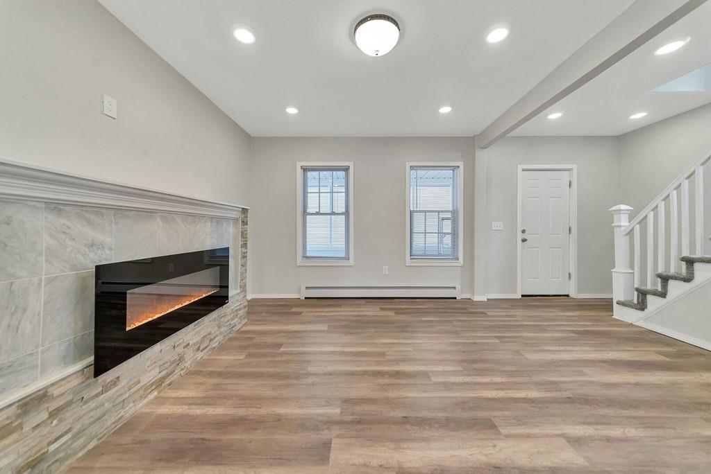 402 Allen Street Springfield, MA 01118 - Photo 11 of 28 a view of an empty room with wooden floor fireplace and a window