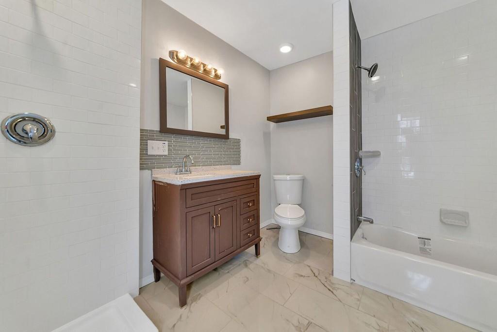 402 Allen Street Springfield, MA 01118 - Photo 19 of 28 a spacious bathroom with a toilet sink and mirror