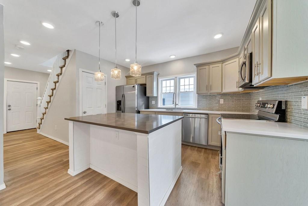 402 Allen Street Springfield, MA 01118 - Photo 7 of 28 a kitchen with stainless steel appliances granite countertop a sink a stove a refrigerator and island with wooden floor