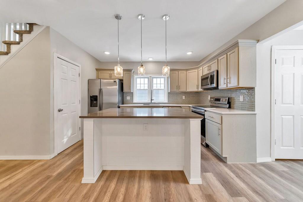 402 Allen Street Springfield, MA 01118 - Photo 8 of 28 a kitchen with stainless steel appliances granite countertop a refrigerator a sink dishwasher a stove and white countertops with wooden floor