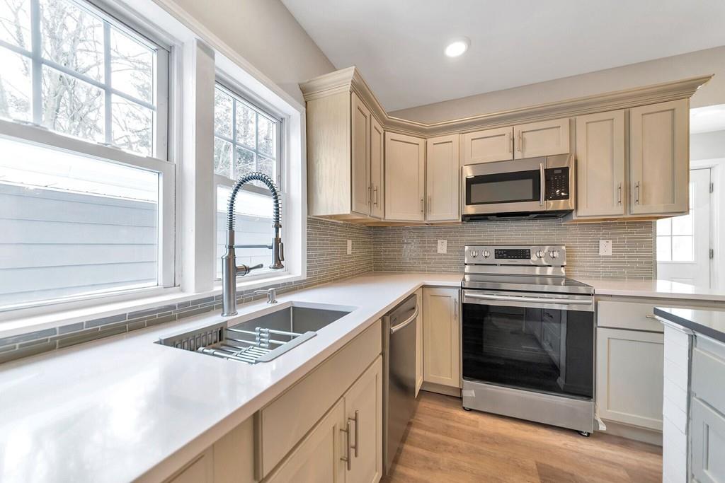 402 Allen Street Springfield, MA 01118 - Photo 9 of 28 a kitchen with a stove a sink and a microwave