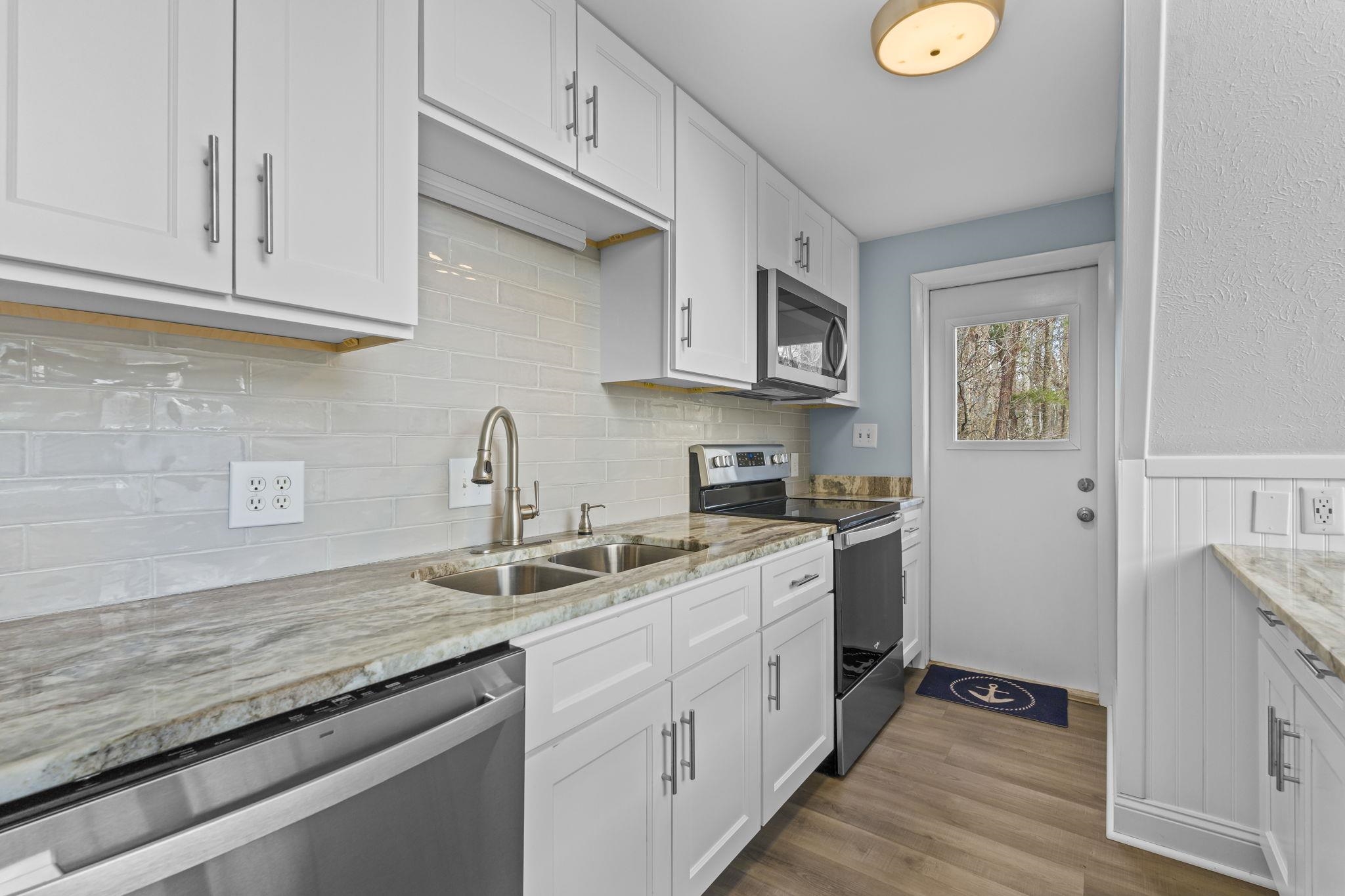 3700 Ed Smith Avenue Myrtle Beach, SC 29588 - Photo 14 of 39 Kitchen with stainless steel appliances, white cabinetry, quartz countertops