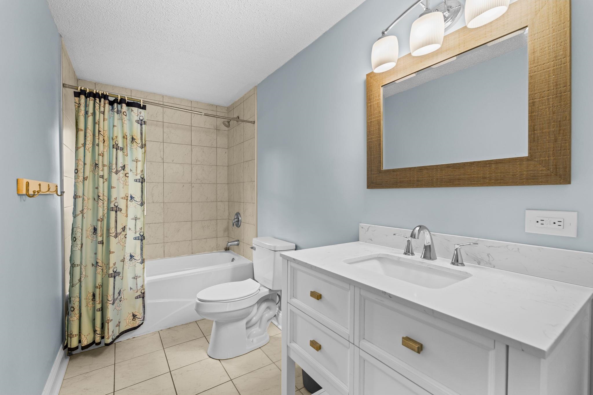 3700 Ed Smith Avenue Myrtle Beach, SC 29588 - Photo 18 of 39 Full bathroom with vanity, shower / bath combo with shower curtain, a textured ceiling, and light tile patterned floors
