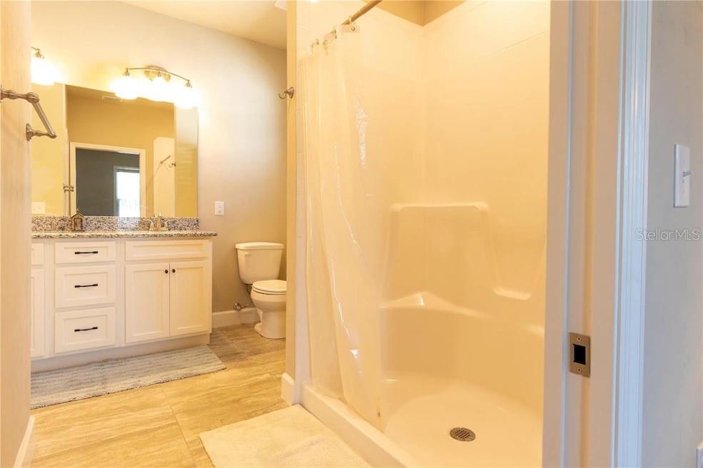 24650 Southwest 17th Place Newberry, FL 32669 - Photo 16 of 19 a bathroom with a granite countertop sink a toilet and a mirror
