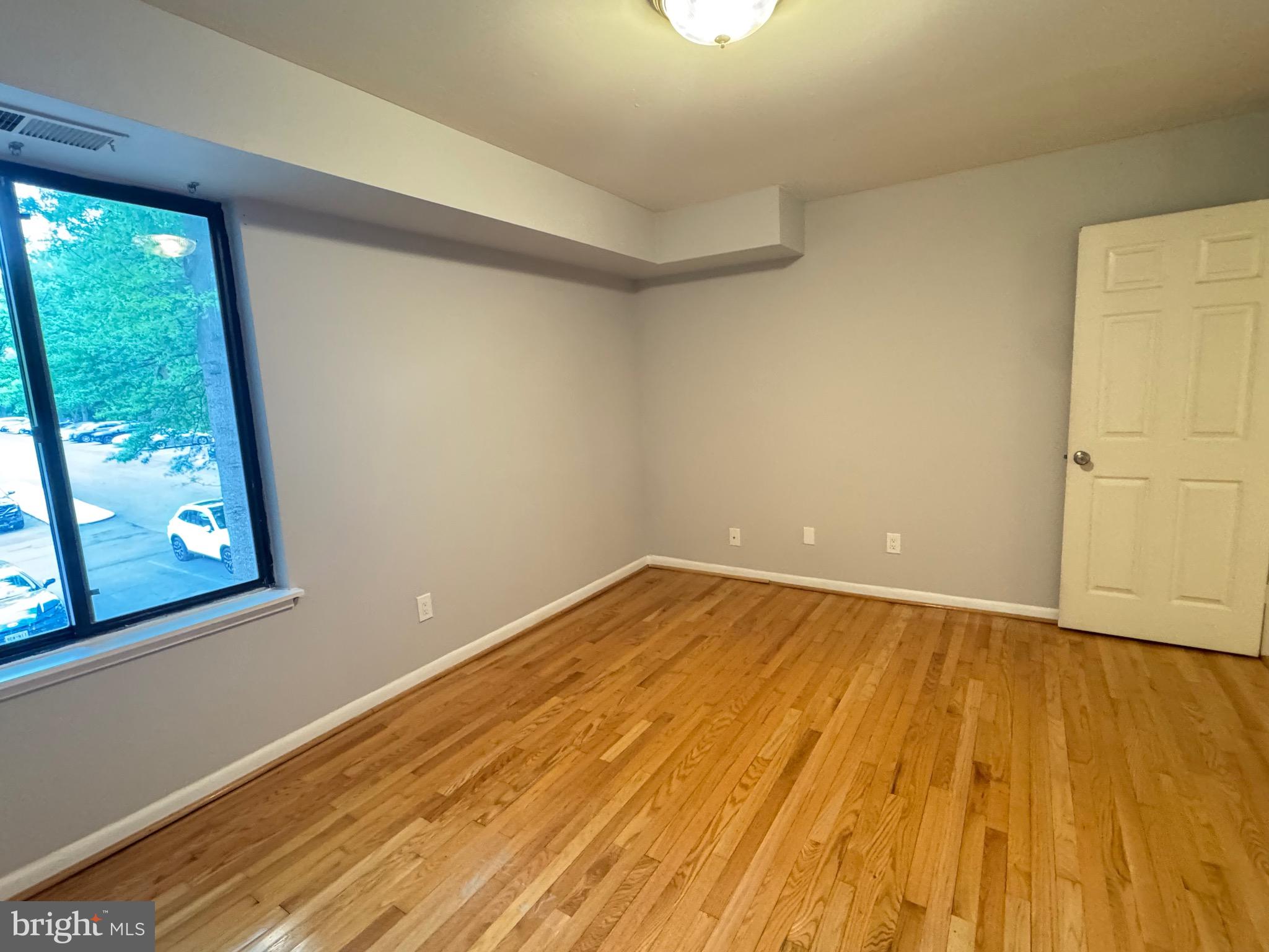 5482 Cedar Lane, Unit B2 Columbia, MD 21044 - Photo 22 of 23 a view of an empty room with wooden floor and a window