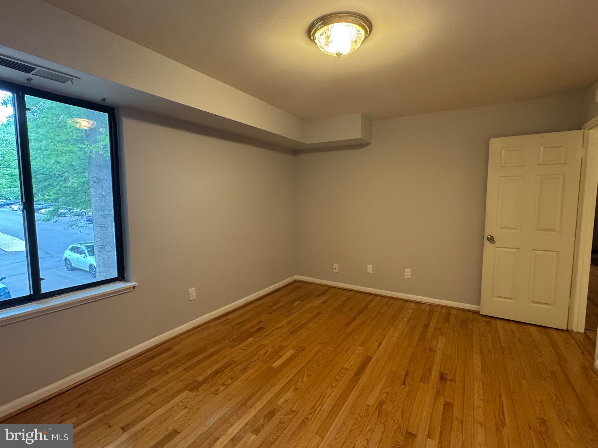 5482 Cedar Lane, Unit B2 Columbia, MD 21044 - Photo 23 of 23 an empty room with wooden floor and windows