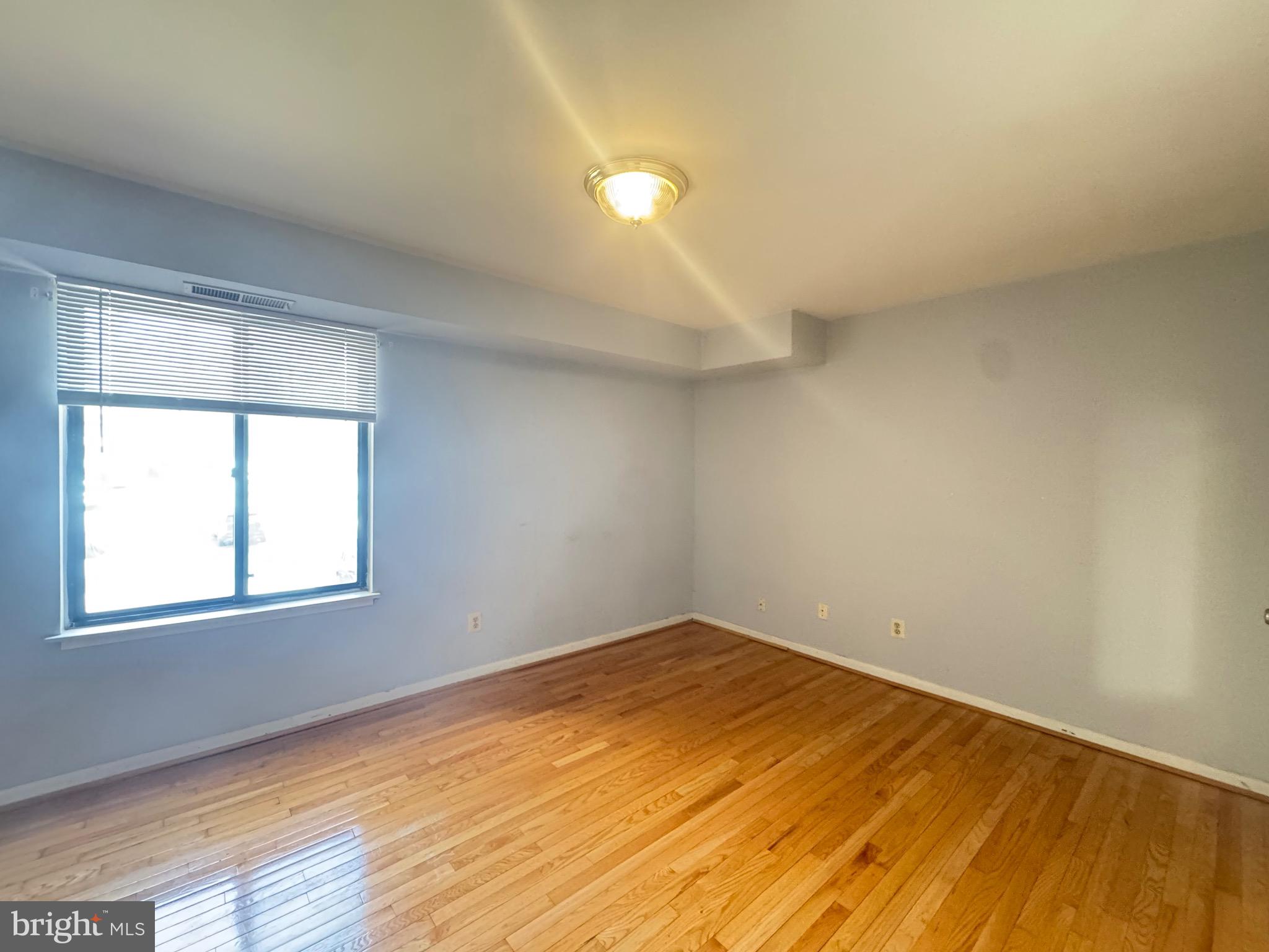 5482 Cedar Lane, Unit B2 Columbia, MD 21044 - Photo 5 of 23 an empty room with wooden floor and windows