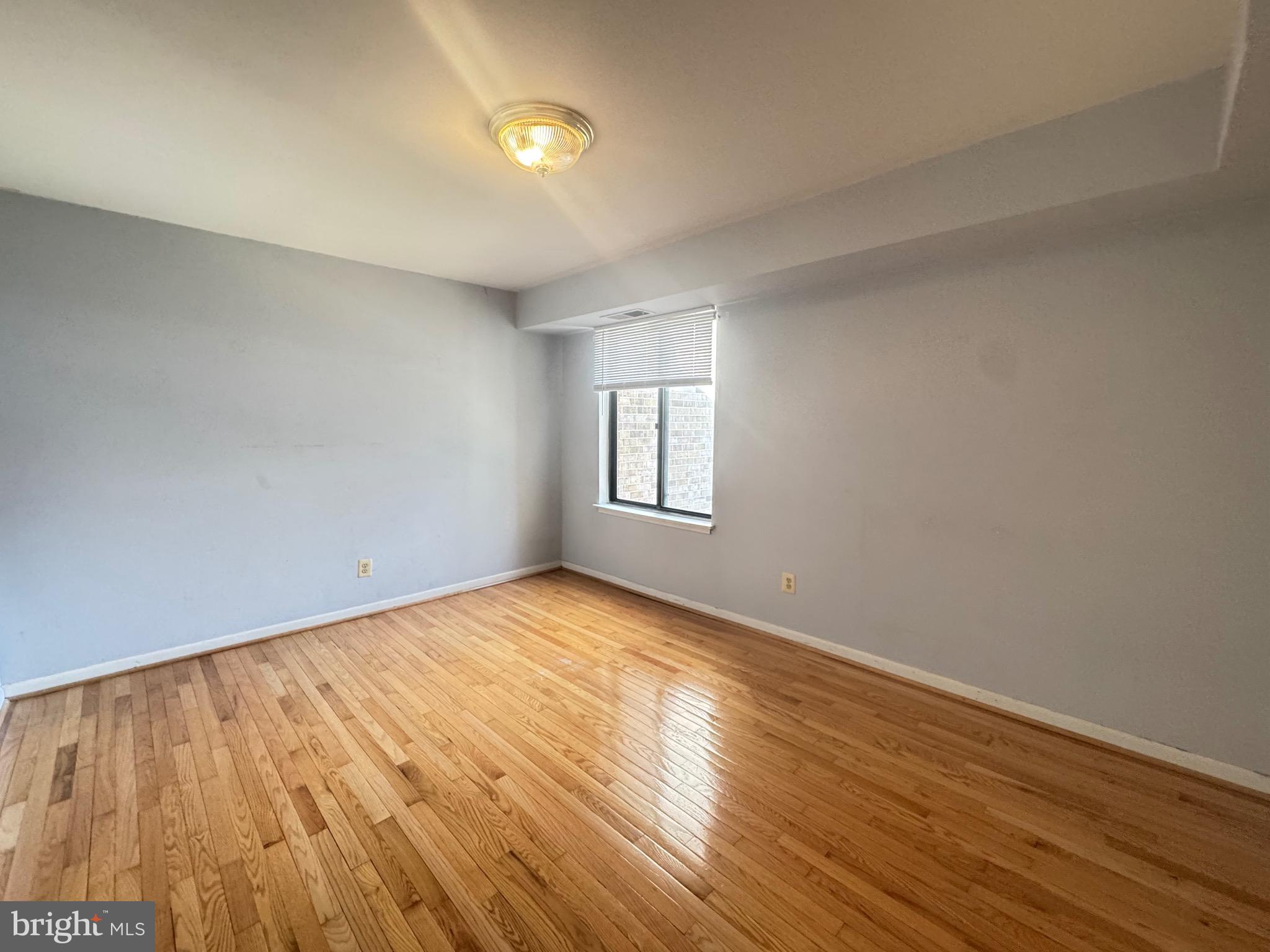 5482 Cedar Lane, Unit B2 Columbia, MD 21044 - Photo 6 of 23 wooden floor in an empty room with a window