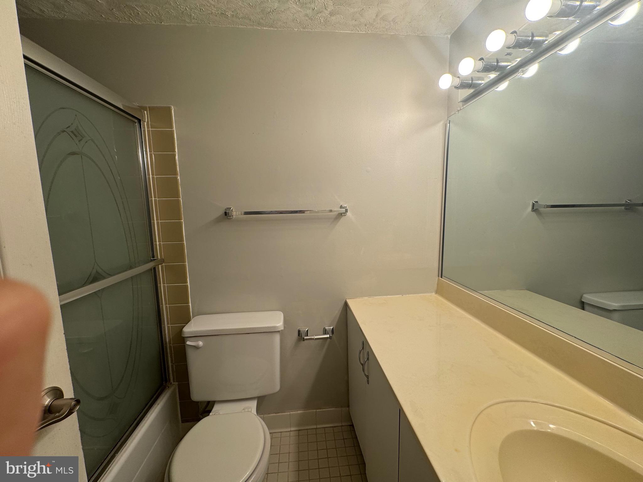 5482 Cedar Lane, Unit B2 Columbia, MD 21044 - Photo 9 of 23 a bathroom with a granite countertop toilet sink and shower