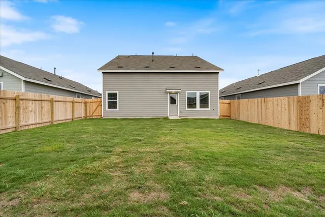a house with green field in front of it