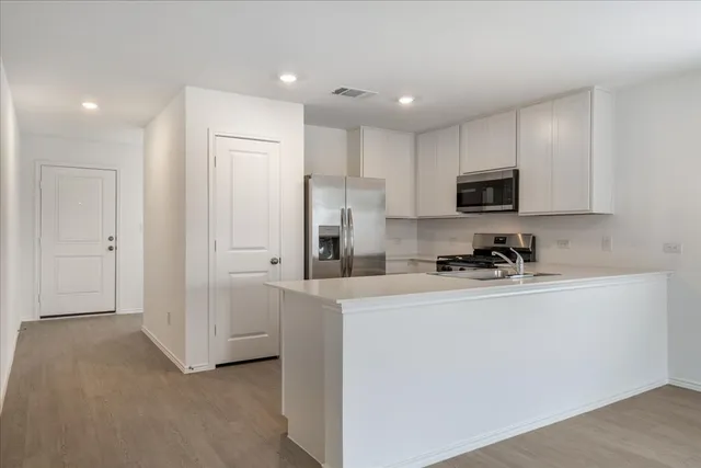 a kitchen with cabinets a sink and stainless steel appliances