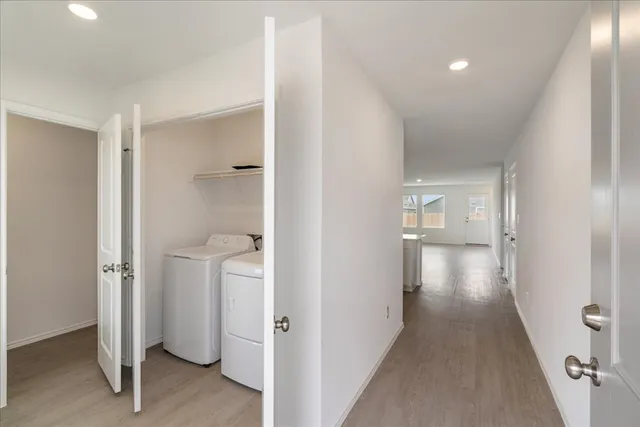a view of a hallway with bathroom and wooden floor