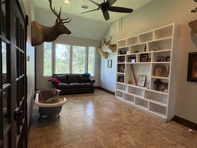 a living room with furniture a window and a ceiling fan