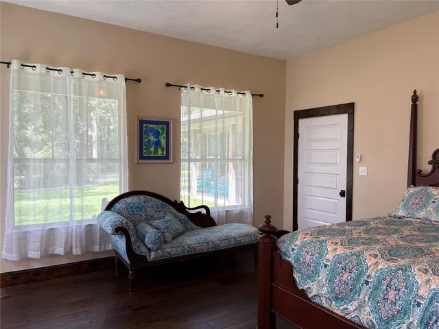 a bedroom with bed couch and window