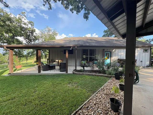 a view of a house with backyard porch and sitting area