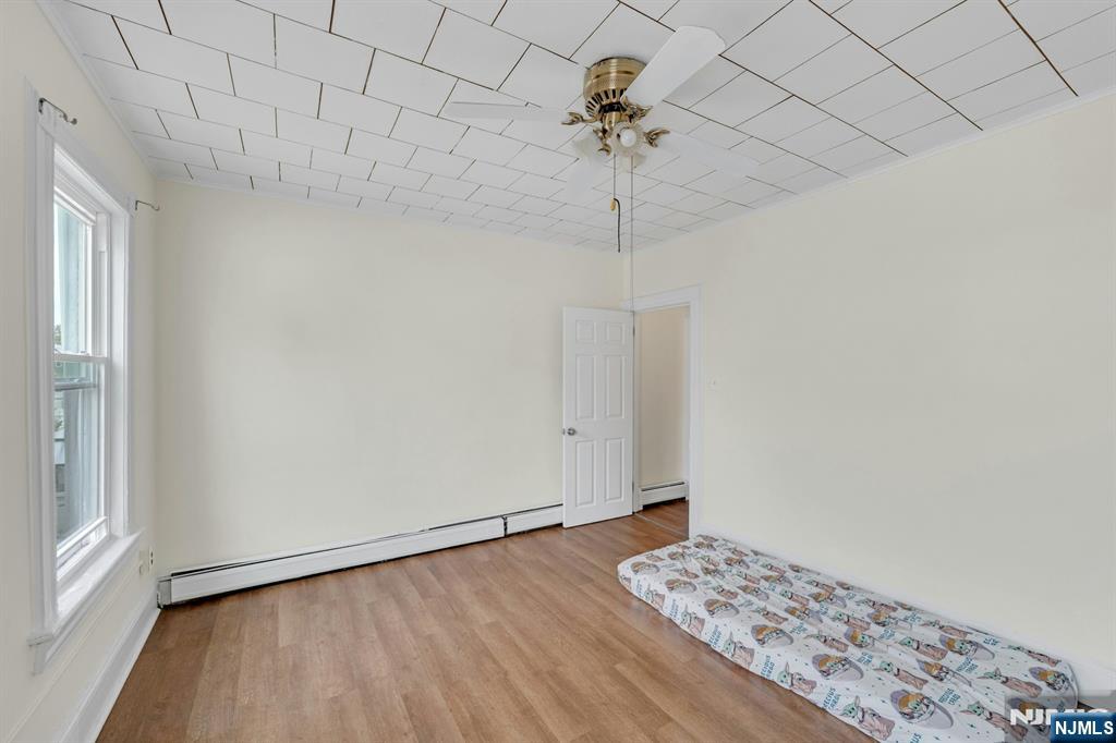 331 1/2 Forest Street Kearny, NJ 07032 - Photo 6 of 17 a view of a room with a chandelier fan and wooden floor