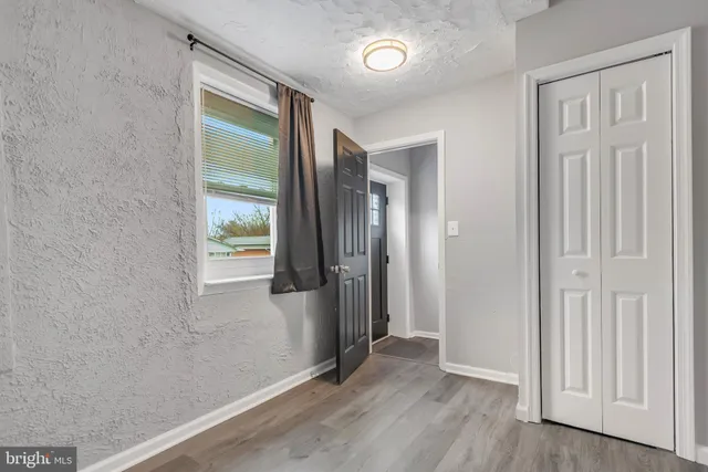 an empty room with wooden floor and a window