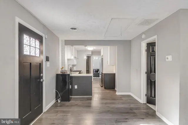 a view of a kitchen with refrigerator and wooden floor