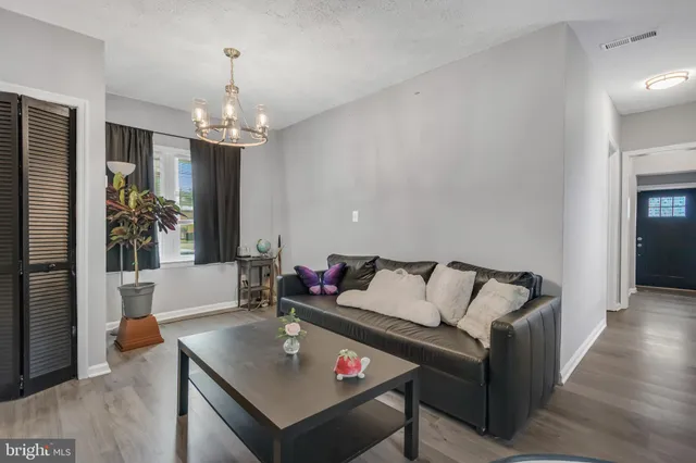 a living room with furniture and a chandelier