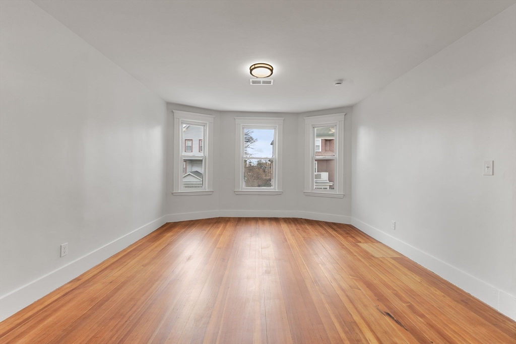 16 Clarkwood Street, Unit 2 Boston, MA 02126 - Photo 11 of 34 a view of an empty room with wooden floor and window