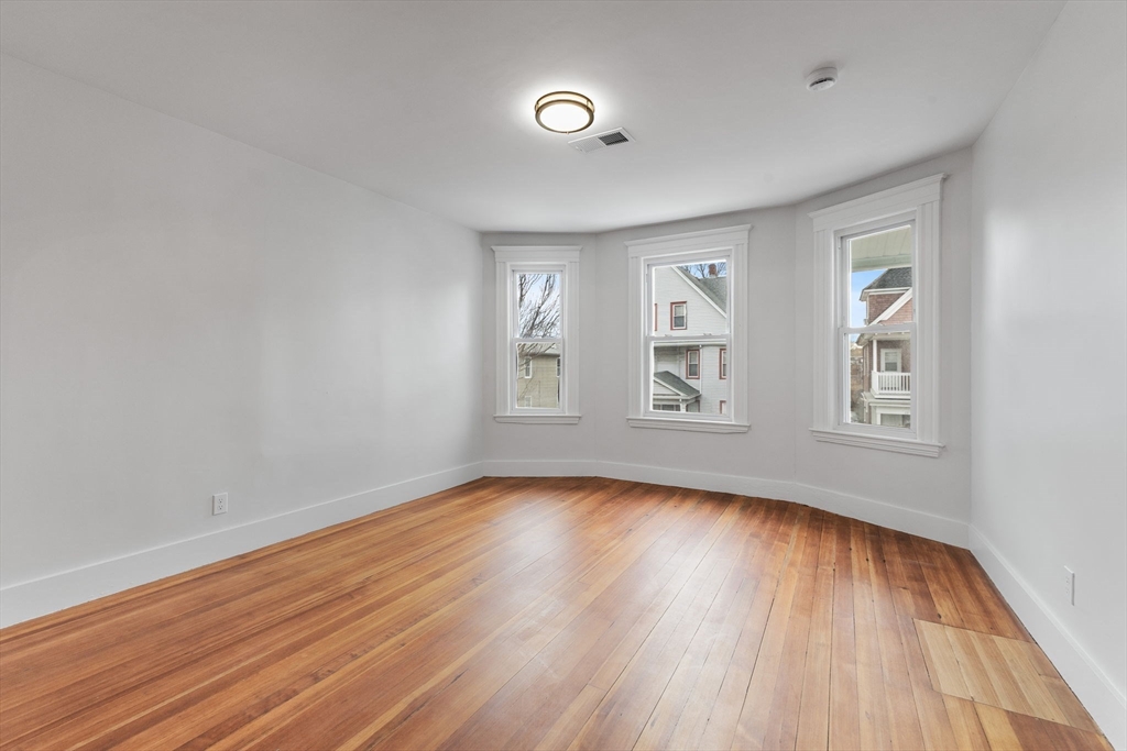 16 Clarkwood Street, Unit 2 Boston, MA 02126 - Photo 12 of 34 a view of an empty room with wooden floor and a window