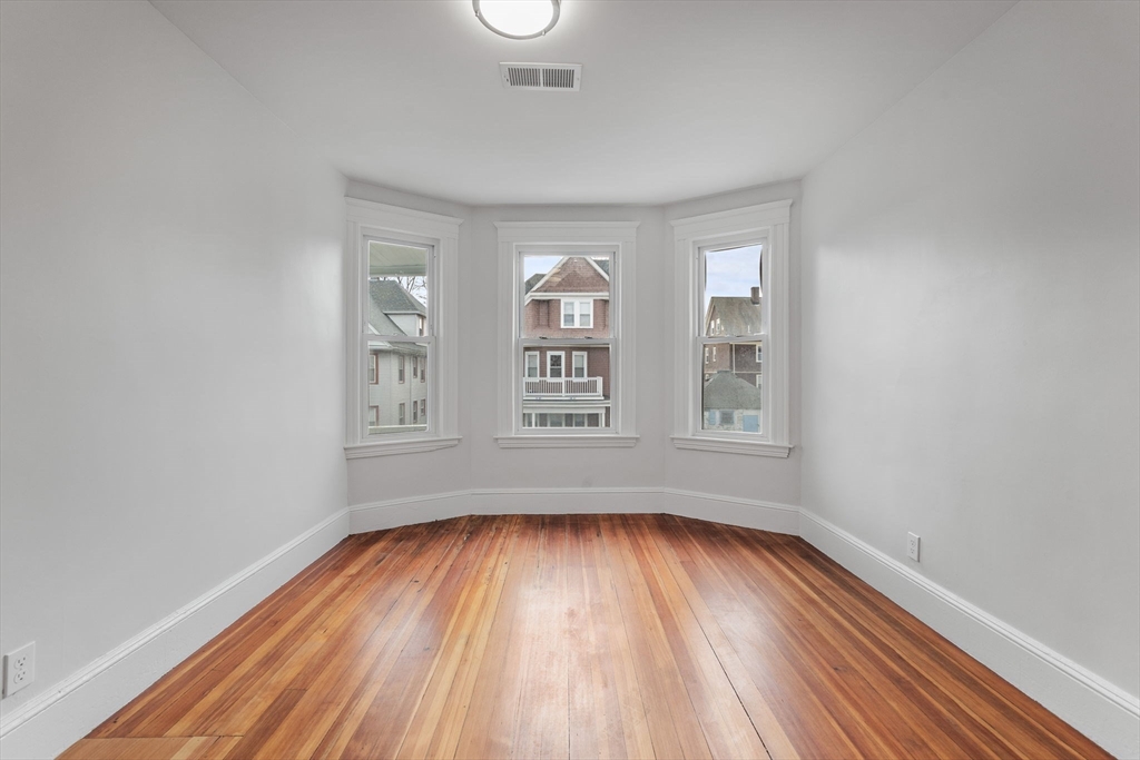 16 Clarkwood Street, Unit 2 Boston, MA 02126 - Photo 15 of 34 a view of an empty room with wooden floor and a window
