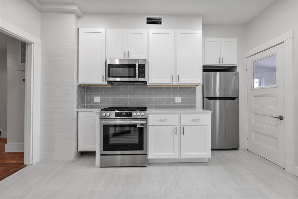 16 Clarkwood Street, Unit 2 Boston, MA 02126 - Photo 2 of 34 a kitchen with stainless steel appliances granite countertop a stove a refrigerator and a microwave