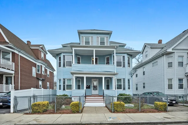 a front view of a residential apartment building with a yard
