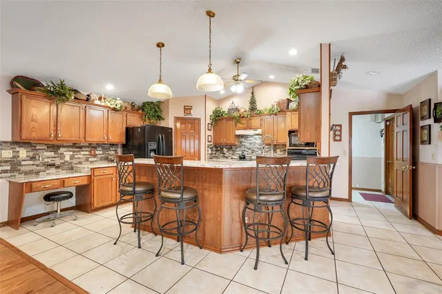 a large kitchen with granite countertop a sink and cabinets