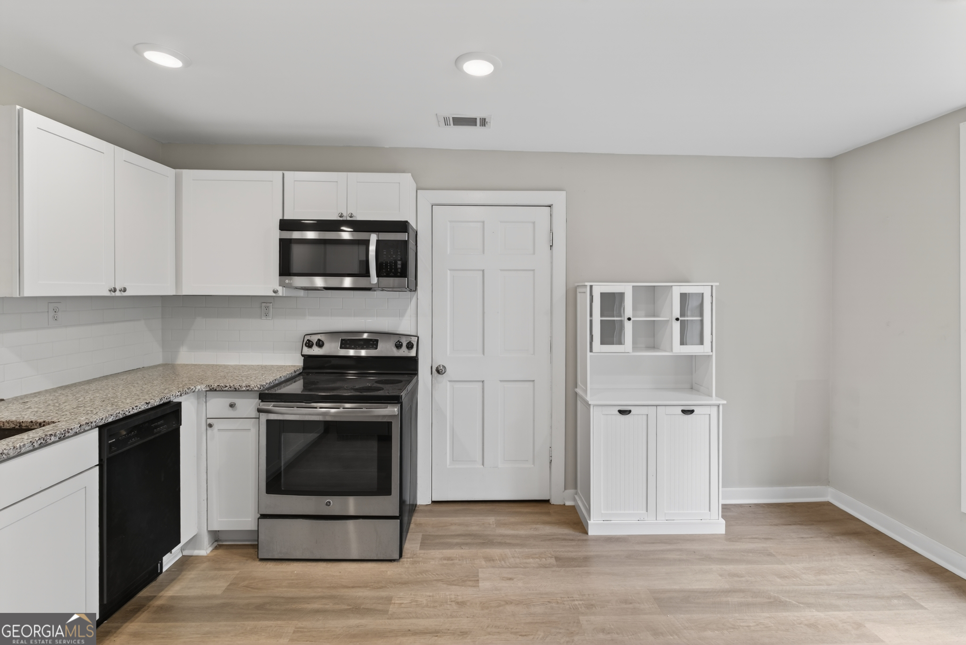 49 Milner Street Temple, GA 30179 - Photo 11 of 32 a kitchen with granite countertop a stove top oven and cabinets