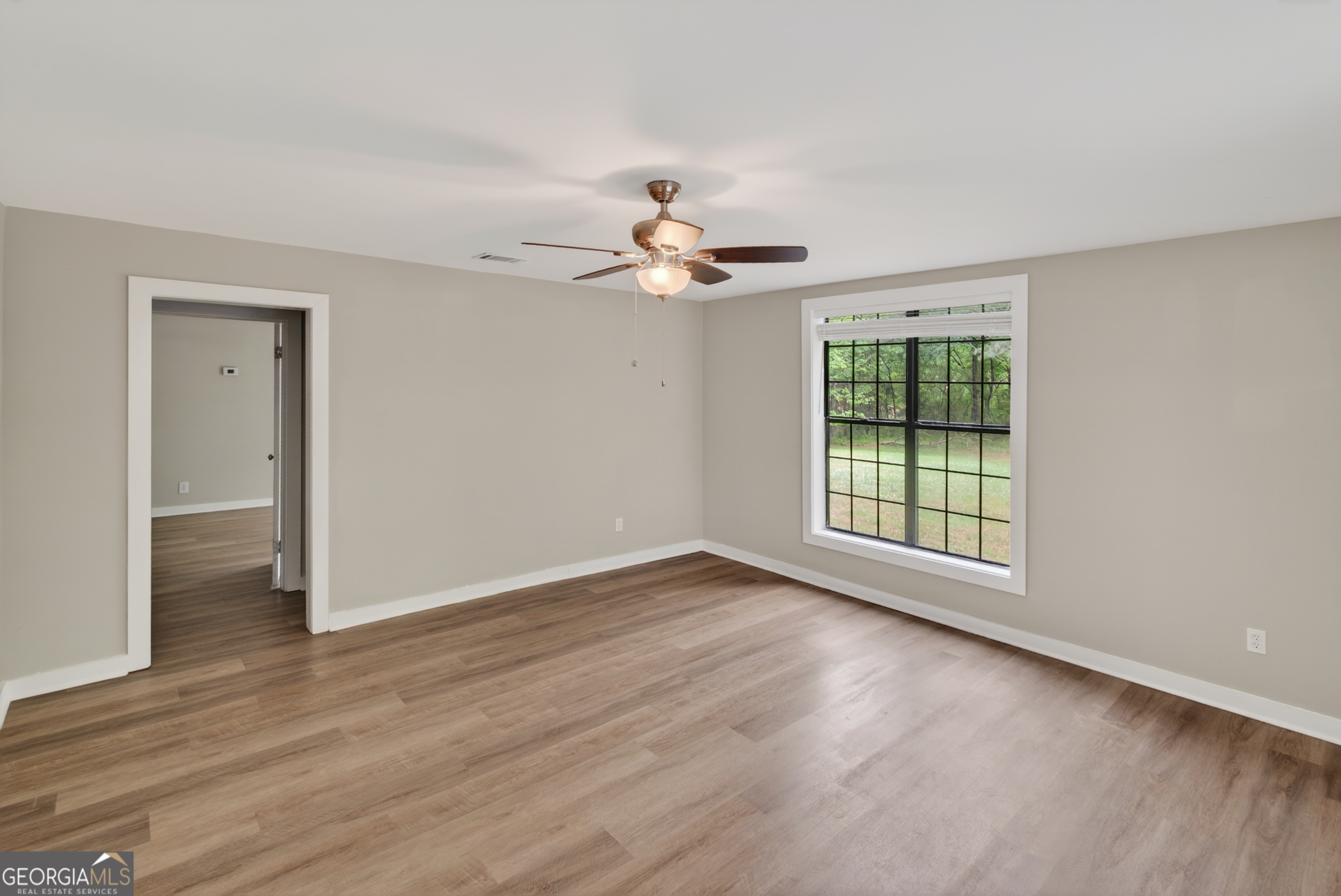 49 Milner Street Temple, GA 30179 - Photo 4 of 32 an empty room with wooden floor chandelier fan and windows