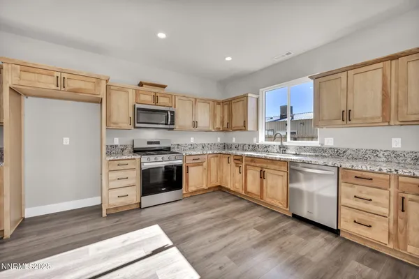 a kitchen with granite countertop white cabinets and stainless steel appliances