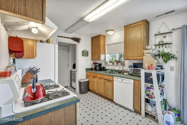 a kitchen with stainless steel appliances kitchen island granite countertop a refrigerator and a sink