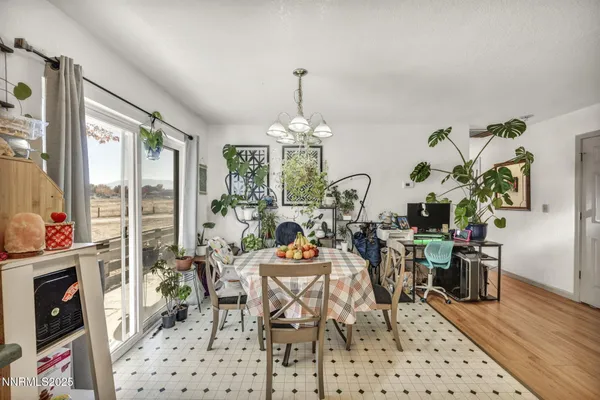 a dining room with furniture a chandelier and wooden floor