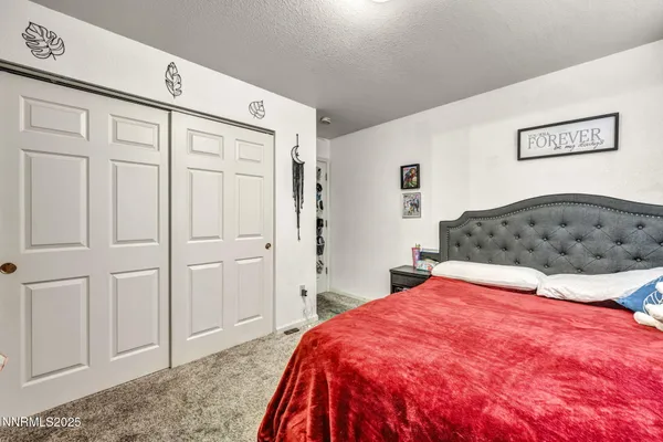 a bedroom with a large bed and a chandelier