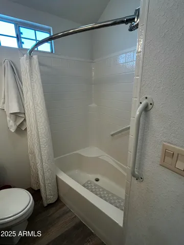 a bathroom with a toilet and a shower
