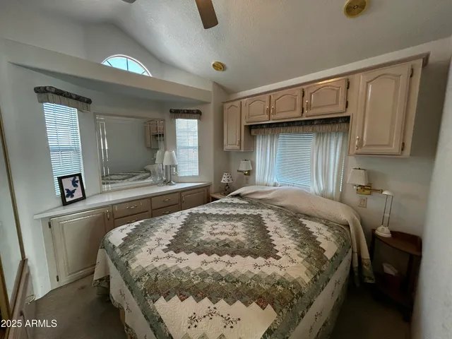 a bedroom with a bed and a large mirror on the dresser