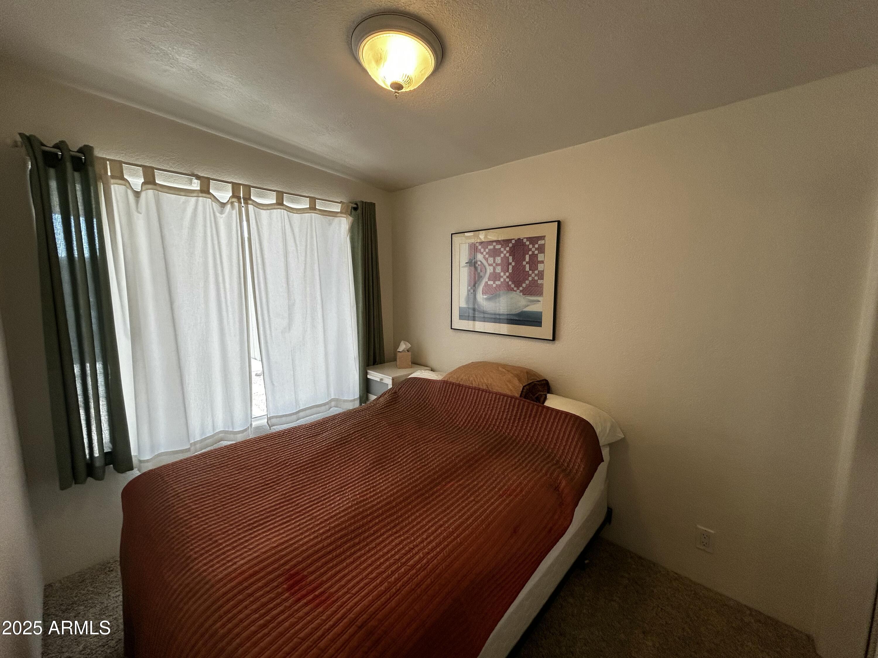 111 South Greenfield Road, Unit 596 Mesa, AZ 85206 - Photo 18 of 26 a bedroom with a bed and a window