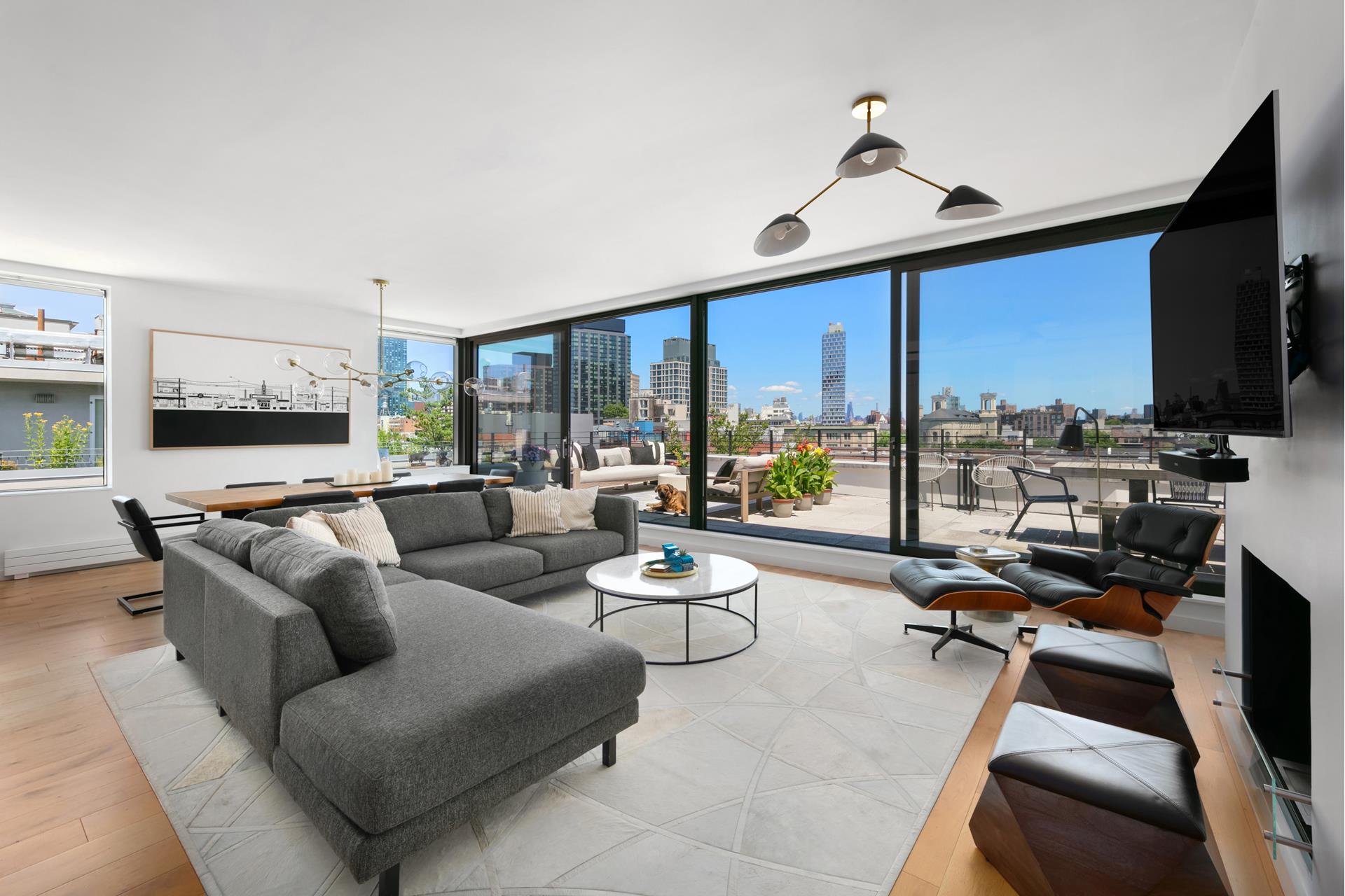 a living room with furniture flat screen tv and a large window