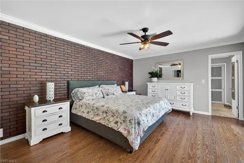 a bedroom with a large bed and a ceiling fan