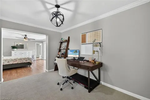 a view of a workspace with furniture and a window