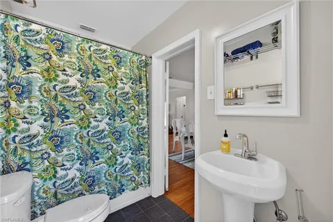a bathroom with a sink a toilet and shower curtain