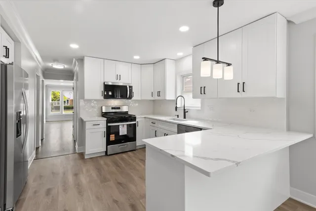 a kitchen with a sink a stove a microwave and a refrigerator