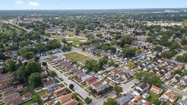an aerial view of residential houses with outdoor space and parking