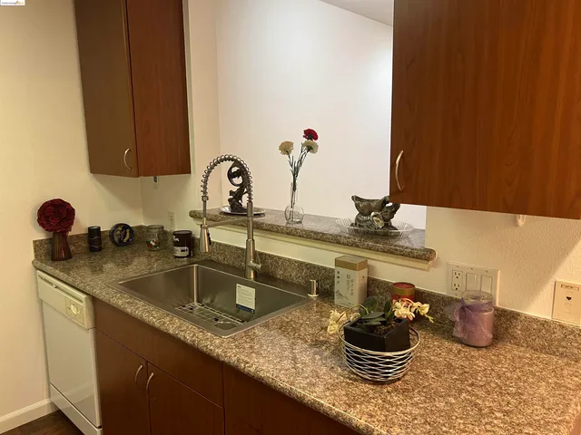 a kitchen with a sink and a stove with wooden cabinets