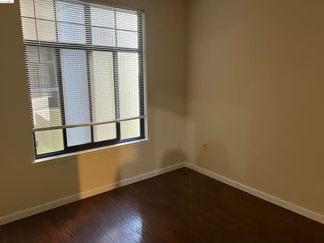 a view of a small space with wooden floor and a window
